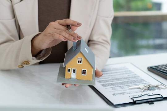 Real Estate Agent Pointing at House Model during Video Call