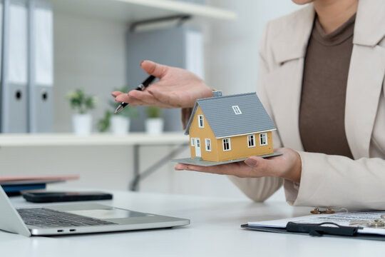 Real Estate Agent Pointing at House Model during Video Call