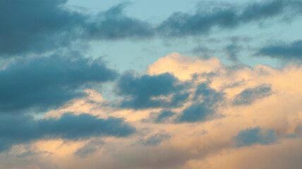 Obraz premium Sunset sky background, colorful fluffy clouds lit by sunshine in the vast evening sky