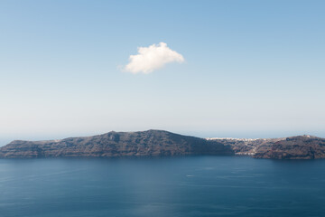 Fototapeta premium Blue sea and the blue sky with white cloud. View of Thirassia island from Santorini island, Greece.