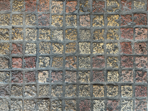 Rough honed andesite slate stone or paving stone in square checkerboard pattern in red, yellow, and grey color. For pavement and sidewalk. Seamless background texture.