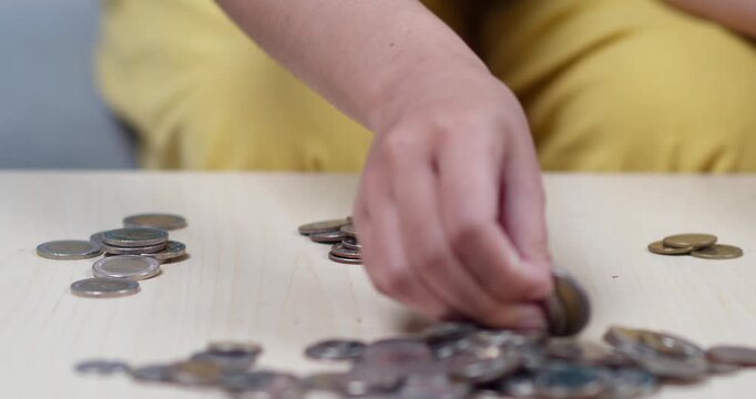 A child meticulously arranges coins showcasing focus and dexterity in a playful learning moment.