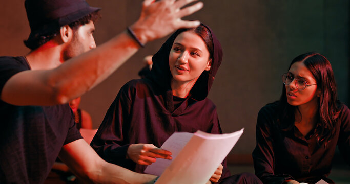 Indian young adult gen z male man female group hold script paper read new story line learn drama at studio teen girl boy team talk speak share new plan idea enjoy day spend break time hall stage place