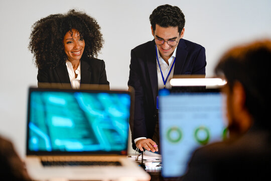 Serious DevSecOps squad collaborating on cloud native security protocols. Diverse IT professionals evaluating privacy preserving AI models and technical paperwork at a tech command center.