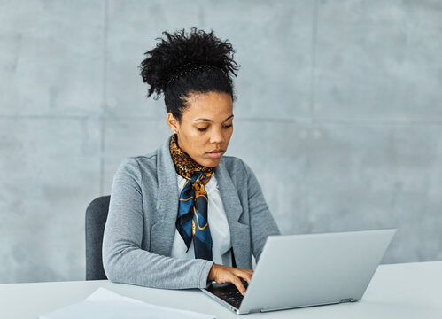 Portrait of a young businesswoman having a meeting in the office. Portrait of a smart young  black businesswoman using a laptop