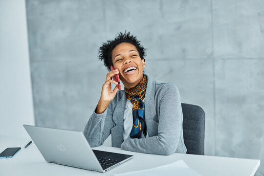 Portrait of a smart young businesswoman using a smartphone phone and texting in the office. Startup and succesful business concept