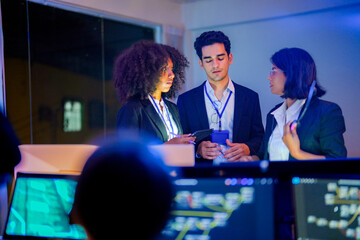 Obraz premium Candid side profile of a focused professional female IT specialist in modern office at night. She has a slight, confident smile while looking off camera. Blurred tech environment.