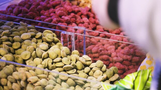 Mehrfaches Bef&uuml;llen von N&uuml;ssen auf Marktstand bei Oktoberfest oder Weihnachtsmarkt