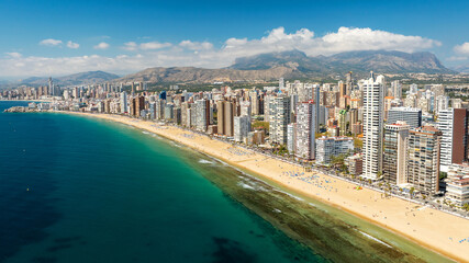 Modern skyscrapers Benidorm Spain Mediterranean coast. Sandy beach high-rise apartment buildings blue sky background sunny weather. Popular European travel destination aerial drone view © marina_larina