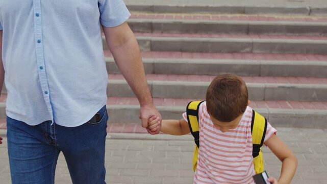 Children safety at crosswalk, Schoolboy in urban setting, Safe routes to school, Son and father on zebra lines, Morning commute with parent, Family crossing street, Teaching road safety skills, Child
