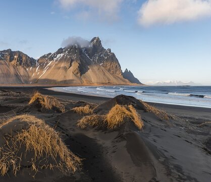 Evening atmosphere, Black sand beach, dunes with dry grass, mountains Klifatindur, Eystrahorn and Kambhorn, headland Stokksnes, massif Klifatindur, Austurland, East Iceland, Iceland
