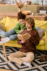 Obraz premium Curly couple shares a cozy moment in their modern apartment, enjoying a book together