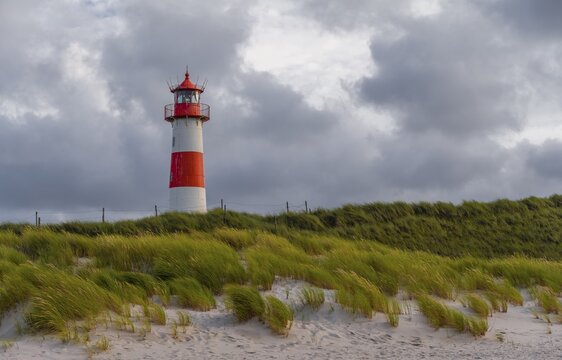 Red-white lighthouse List-Ost in the dunes in front of cloudy sky, Ellenbogen, Sylt, North Frisian Island, North Sea, North Frisia, Schleswig-Holstein, Germany