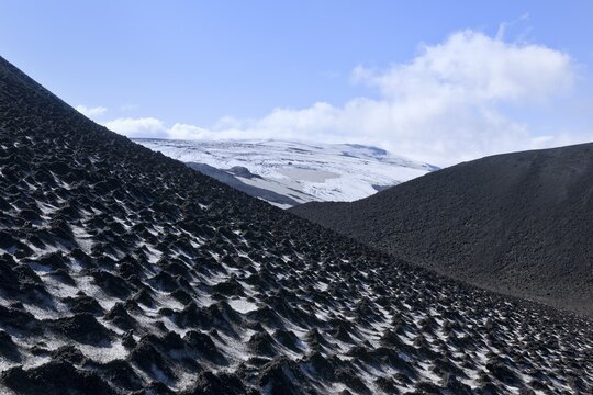 Ash-covered snowfield with the Eyjafjallaj&ouml;kull on the long-distance hiking trail from Sk&oacute;gar via Fimmv&ouml;r&eth;uhals to the Th&oacute;rsm&ouml;rk mountain ridge, &THORN;&oacute;rsm&ouml;rk, Iceland