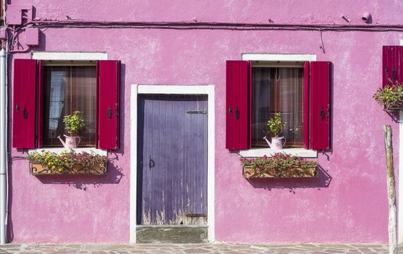 Pink house with windows and floral decorations, colorful facade, morbid, Burano island, Venice, Veneto, Italy