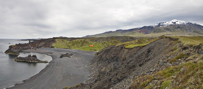 Lava rock formations along the coast and Mt. Snaefellsjoekull in the background, Djupal&oacute;nssandur, Snaefellsness Peninsula, Iceland, Atlantic Ocean