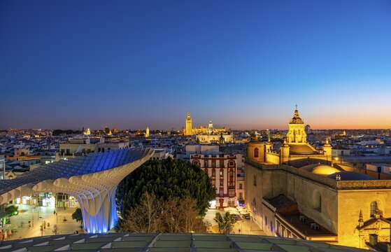 View from Metropol Parasol over the city, illuminated Cathedral of Seville with tower La Giralda, blue hour, Seville, Andalusia, Spain