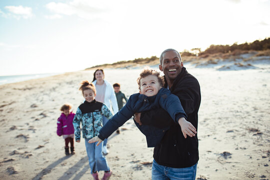 Happy family walking and playing on beach