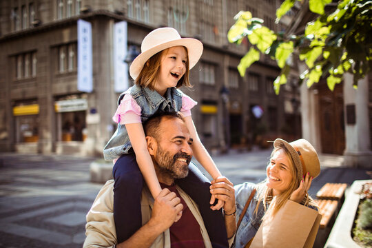 Happy family shopping on a sunny city street