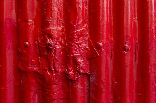 Corrugated iron, painted red, partially repaired