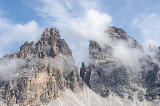 Three Peaks of Lavaredo, mountain tops covered by clouds, south face, Sexten Dolomites, Belluno, Italy