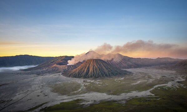 Volcanic landscape at sunrise, smoking volcano Gunung Bromo, with Mt. Batok, Mt. Kursi, Mt. Gunung Semeru, Bromo-Tengger-Semeru National Park, Java, Indonesia