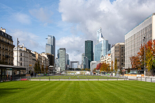 Urban park contrasts modern corporate architecture and skyline in Paris business district at La Defense highlighting district scale and business city growth