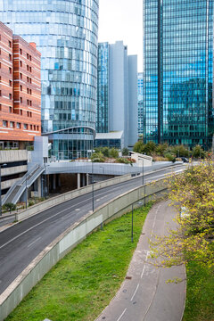 Highway curves through Paris business district at La Defense beneath corporate skyscraper architecture showing modern urban skyline and district atmosphere