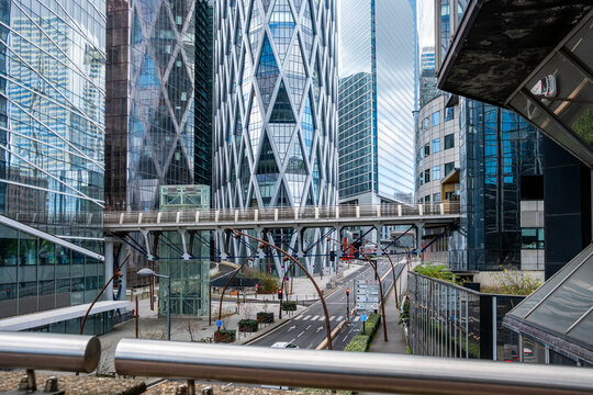 Street level view of modern corporate skyscraper architecture and glass facade in urban city near Paris business district at La Defense with reflections