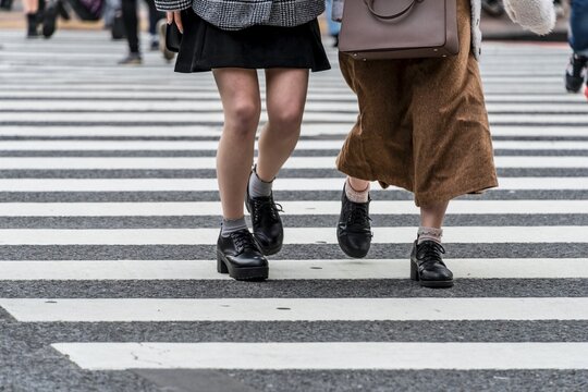 Two pedestrians crossing zebra crossing, close-up, Shibuya Crossing, Shibuya, Udagawacho, Tokyo, Japan