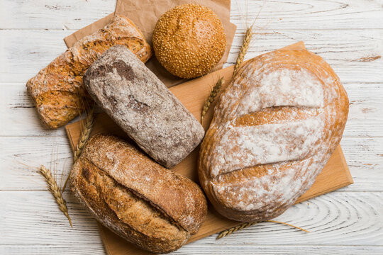 Assortment of freshly baked bread with napkin on rustic table top view. Healthy unleavened bread. French bread