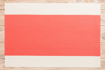 Naklejka premium Top view of red tablecloth for food on wooden background. Empty space for your design