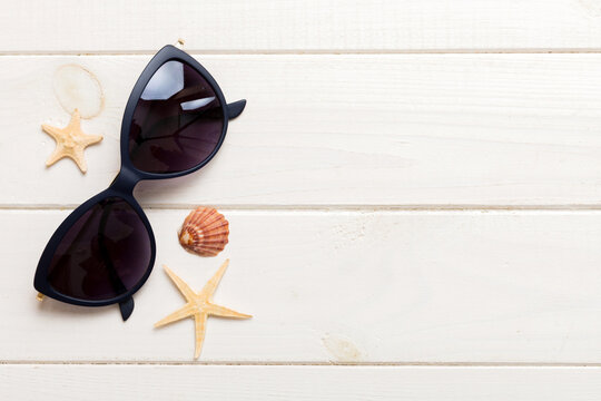 sunglasses with seashell lying on table background. Sunglasses on summer background. Top view flat lay with copy space for text