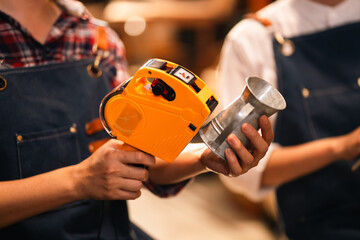 Measuring cup mold and tape measure in workshop, skilled craft person making metal cup with focused...