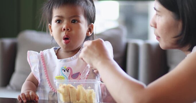 Toddler choking while eating, food spilling out, Coughing, Baby surprised expression, Food stuck in throat, Having difficulty breathing, Candid real-life moment, Child care, safety, and supervision