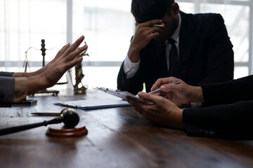 Lawyers discussing and signing legal contract with stressed client in office
