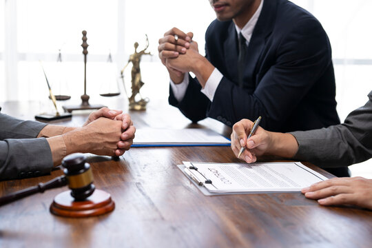 Lawyers and client reviewing contract before signing legal document in office