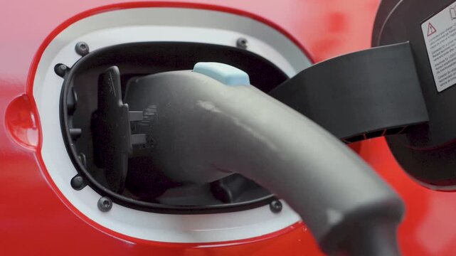 Hand Plugging Charging Cable Into Electric Car Port For Clean Energy Transportation