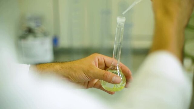 Scientist Handling Pipette and Flask in Laboratory During Scientific Experiment