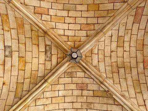 Replica of medieval Roman underground vault architecture with curved and ribbed vault ceiling made of stone bricks. Roman pillars with intricate details or carved capitals. Medieval atmosphere