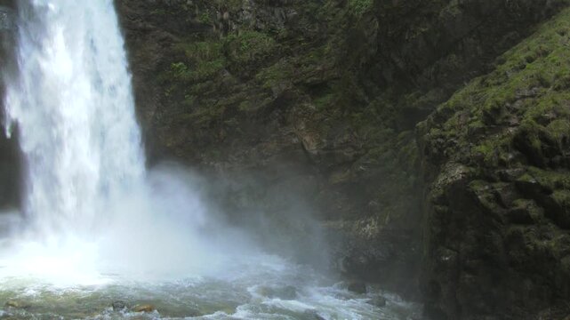 Large natural waterfall at Tarapoto crashing down in Peru Amazon rainforest with swirling mist. Tropical forest, rocky gorge, watercourse, and freshwater depict freshwater geography and habitat value.