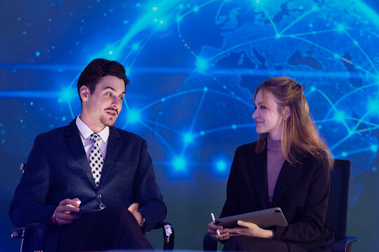 Two business professionals are having a conversation in a conference setting