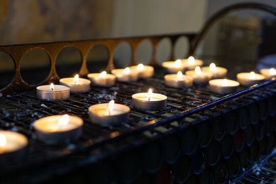 Burning tea lights on church stand