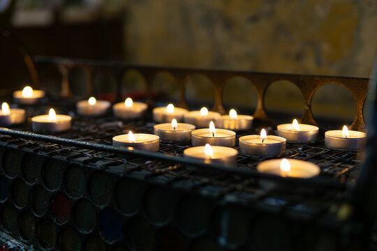 Votive candles glowing in dark temple