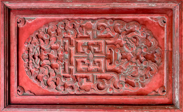 Close up of traditional royal carving in oriental Chinese motifs carved on a red frame wood. Wooden carvings with random geometric and floral vines and swirls Chinese. Seamless texture