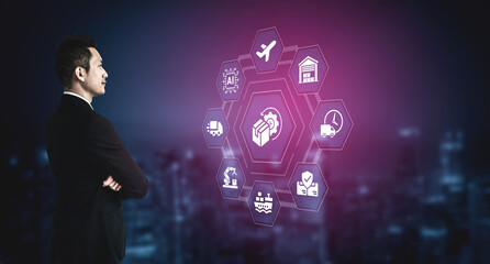 A businessman stands in a suit, analyzing digital logistics and e-commerce icons. The futuristic city backdrop emphasizes innovation and strategy in modern business practices. Ledger © InfiniteFlow