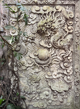 Close up of dragon and cloud Chinese carved wall in oriental Asian concept. Chinese dragon cloud and pagoda sculpted panel usually found in temples. Seamless background texture.