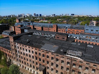 Naklejka premium Lodz city in Poland. Lodz industrial heritage with renovated historic Scheibler textile factory in background and deteriorated abandoned second factory in foreground.