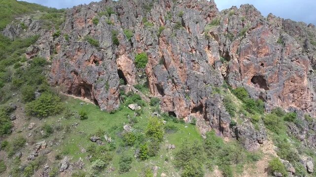 Aerial view of limestone karst cliffs with cave cavities and rugged rocky formations landscape. Arid terrain, calcareous, topography, wilderness depict regional geology natural history.