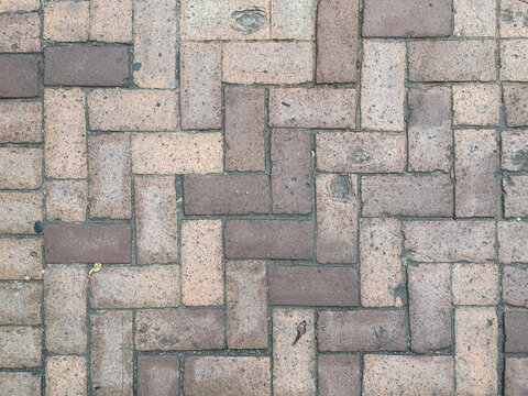 Brown rustic brick and wood in chevron pattern. Natural weathered red bricks in inverted chevron shape arrangement. Seamless background texture.